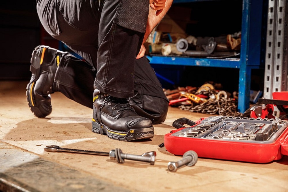 A person in a work boots next to a toolbox